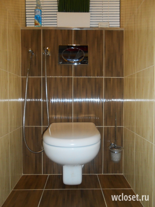 Небольшой туалет с гигиеническим душем, скрытым за жалюзи бойлером и с инсталляцией