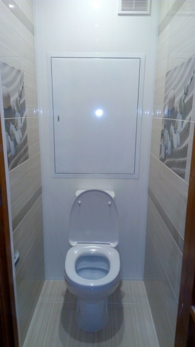 Небольшой туалет с сантехнической дверью и плиткой на стенах и на полу