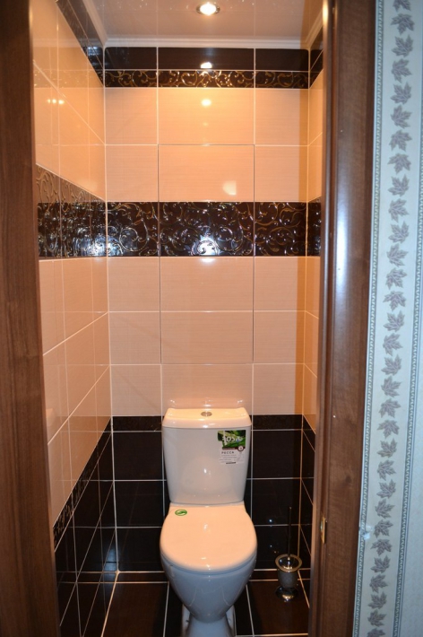 Бежево-черный дизайн туалета с небольшим шкафом за дверцей без ручек