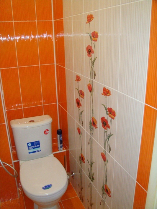 Оранжевый маленький туалет с гигиеническим душем и коробом для труб
