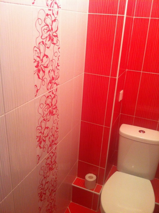 Туалет с натяжным потолком, коробом для труб и плиткой красного цвета